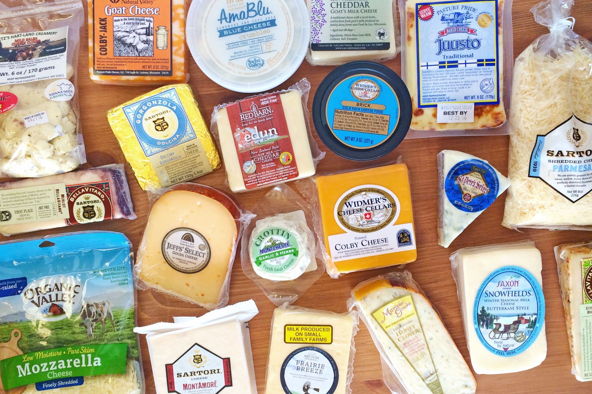 Large array of cheese products on a wooden table
