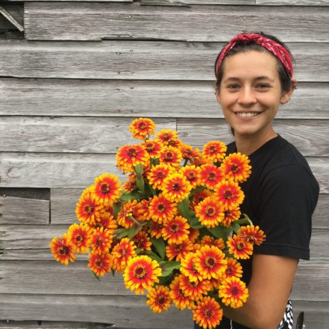 Woman holding yellow and orange flowers