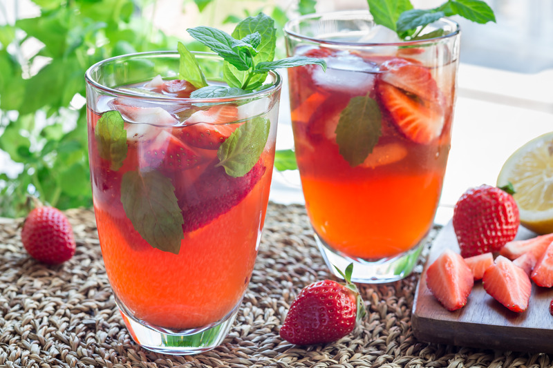 Glass of refreshing iced tea with strawberries and mint