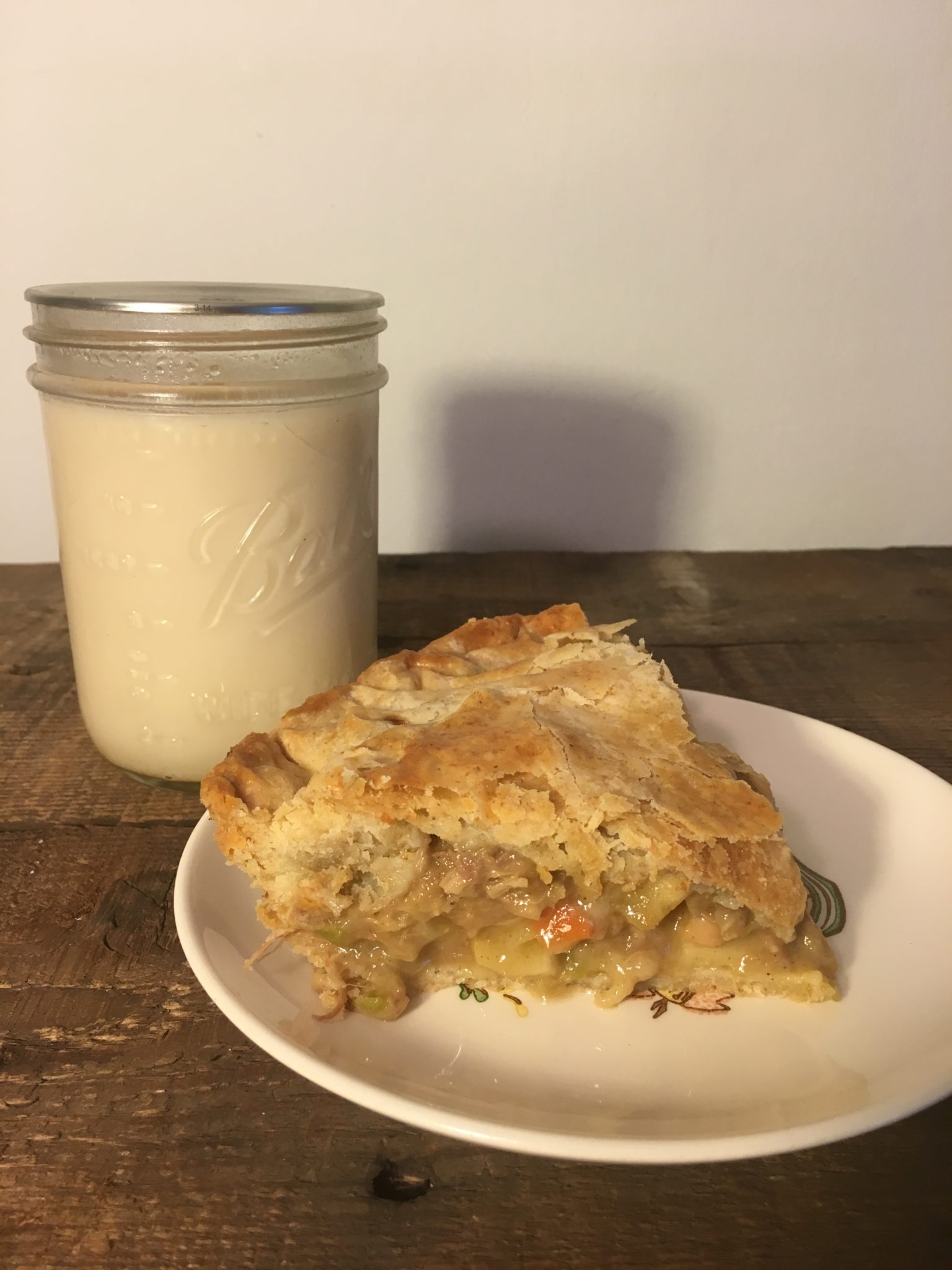 a slice of pot pie with a glass of milk