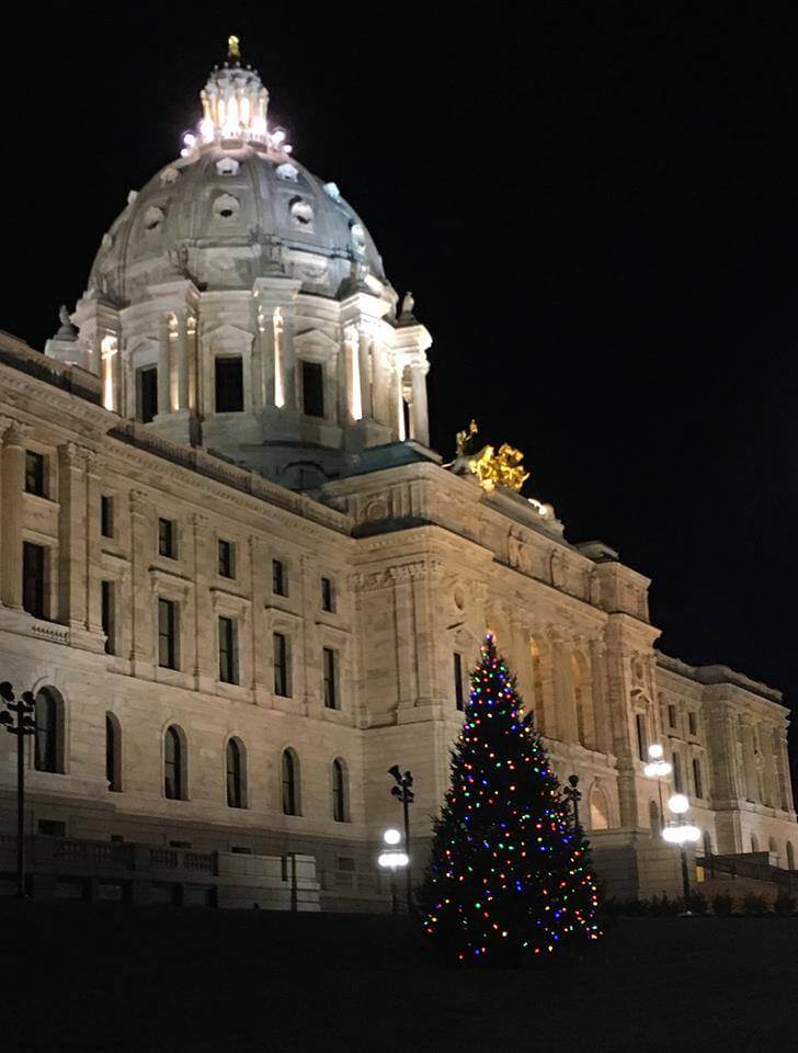 Lit Christmas tree in front of Minnesota State Capitol building