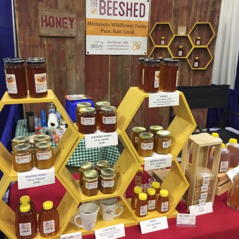 table display of The Bee Shed honey consisting of bars, jars, and spreadable