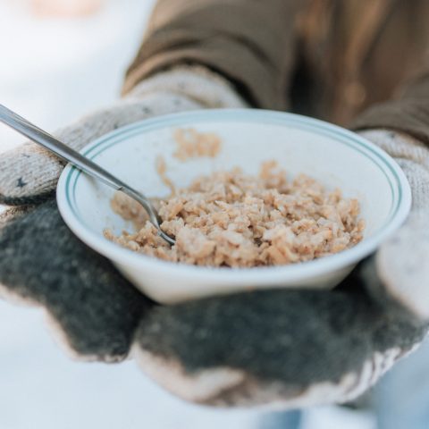 Winter hands holding a bowl of granola