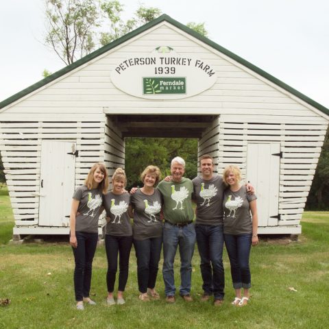 Peterson family posing in front of an old white grainery