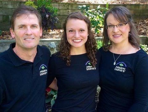 Three family members wearing navy company shirts