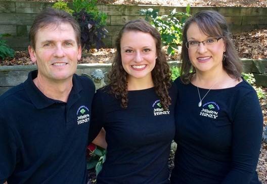 Three family members wearing navy company shirts