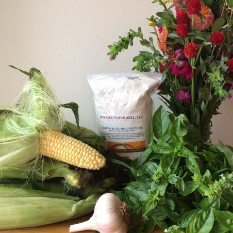 Posed picture of corn, flowers, garlic
