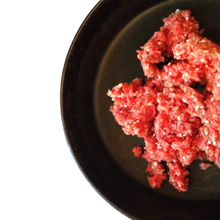 Ground meat on a black platter.