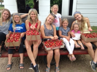 group photo with flats of freshly picked strawberries