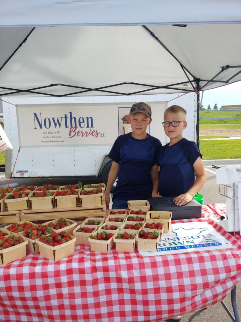 boys selling berries at the market