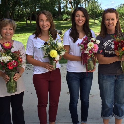 women holding completed bouquets from a flower course