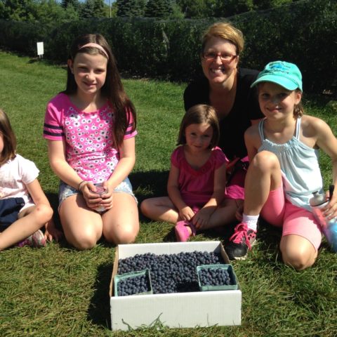 family photo with a flat of blueberries