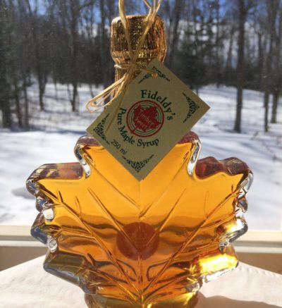 maple syrup bottle shaped like a maple leaf with snowy background