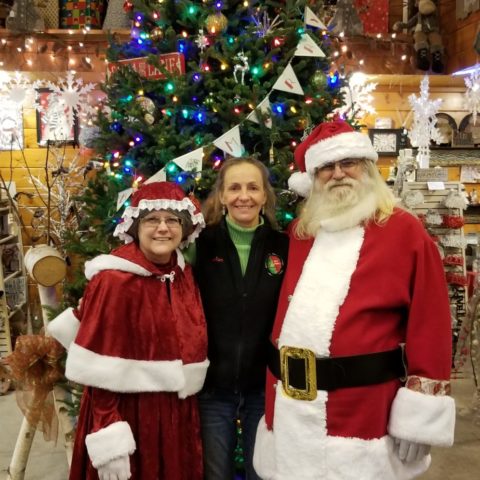 Owner Jan, standing with Mrs Claus and Santa in front of a christmas tree