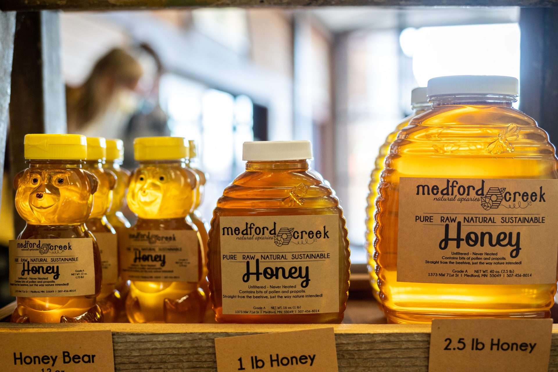 a shelf with jars of honey and soft backlight