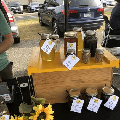jars of honey on a wood table at a farmers market