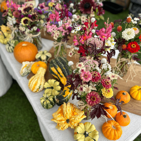 Picture of a table with floral arrangements, gourds, and pumpkins