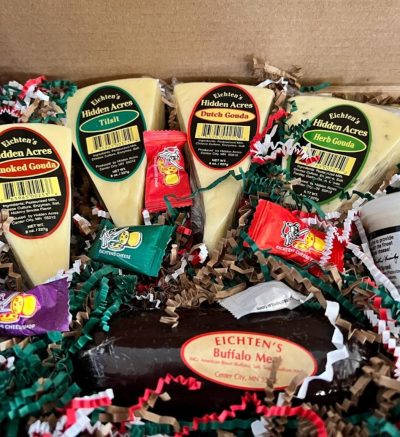 four cheese wedges sit in multi color kraft paper krinkle with buffalo summer sausage