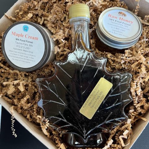 maple syrup, maple cream, and raw honey in a gift box with brown krinkle paper