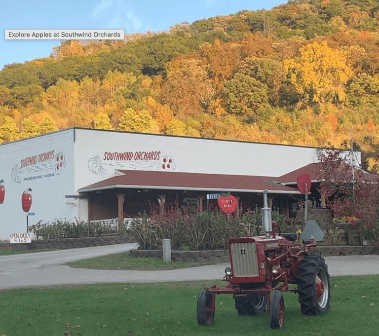 Southwind Orchards building with tractor in foreground and hills in fall colors in the background
