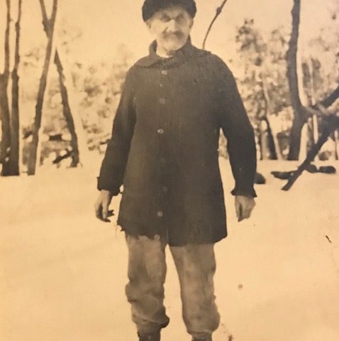 person standing in a snowy forest in a an old photo