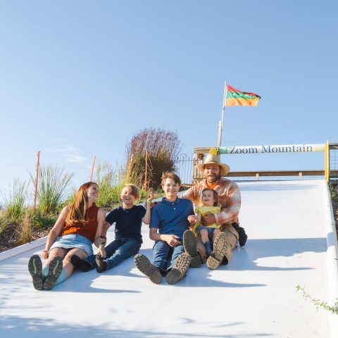A family enjoys the "Zoom Mountain" slide on the farm.