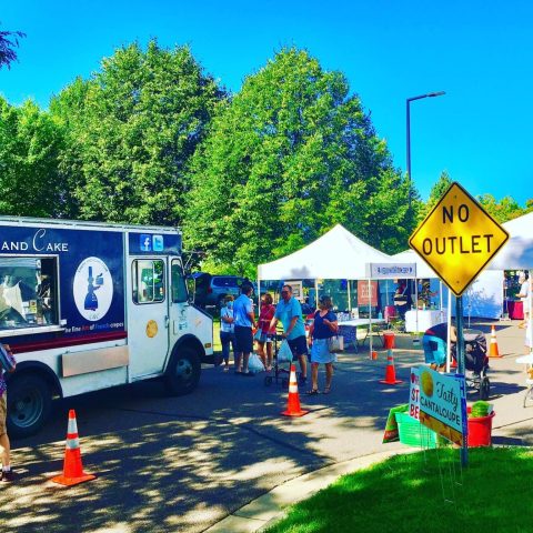 View of the market stands and Crepe and Cake food truck.