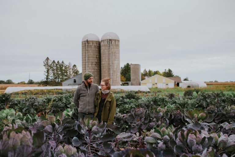 couple standing in front of farmstead