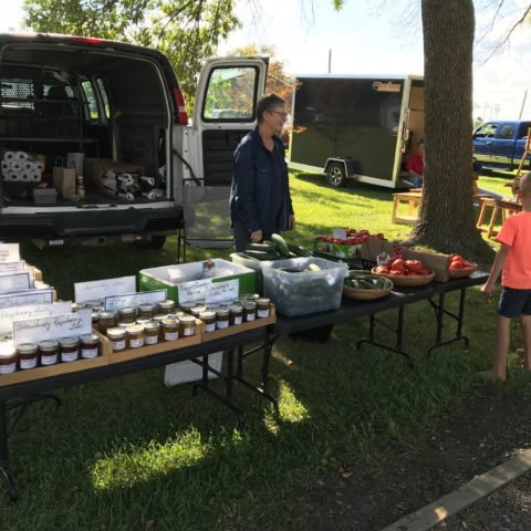 vendor selling preserves at outdoor farmers market