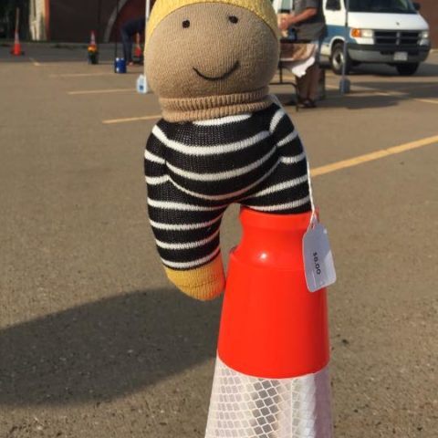 small knitted toy sticking out of the top of a traffic cone