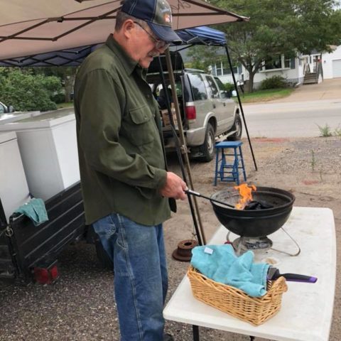 person grilling at a market booth