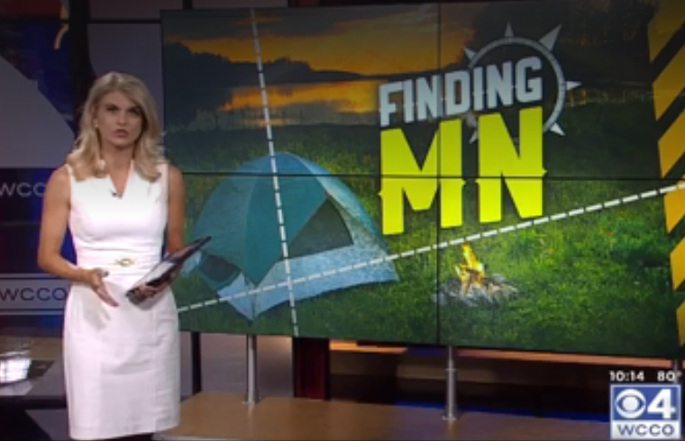 reporter for CBS standing in front of screen that says "Finding MN"