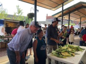 Governor Walz posing with corn shucking contestants