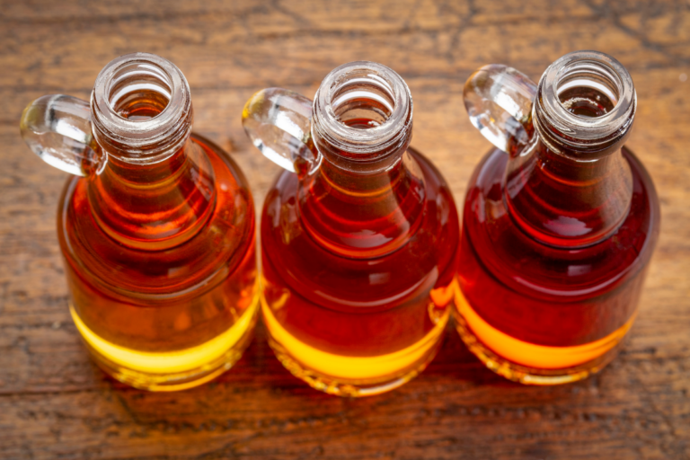 Three golden bottles of maple syrup.