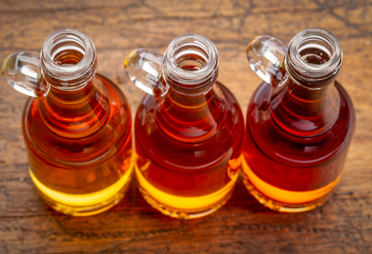 Three golden bottles of maple syrup.