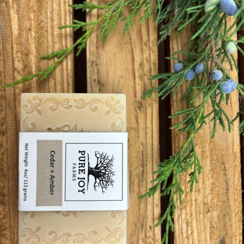 Packaged Pure Joy Farms soap that says "Cedar & Amber Net Weight 4oz/113 grams" embossed with a Victorian-like design.