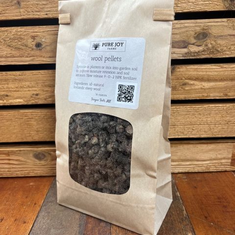 Packaged Pure Joy Farms wool pellets in a light tan bag with a label that says "wool pellets. Sprinkle in planters or mix into garden soil to improve moisture retention and soil aeration. Slow release 9-0-2 NPK fertilizer. Ingredients: all-natural Icelandic sheep wool. 16 ounces. Fergus Falls, MN.