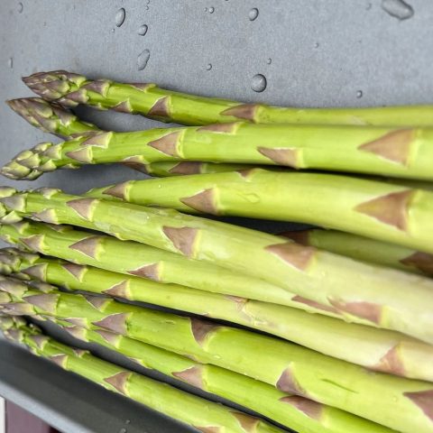 A tray of fresh green asparagus.