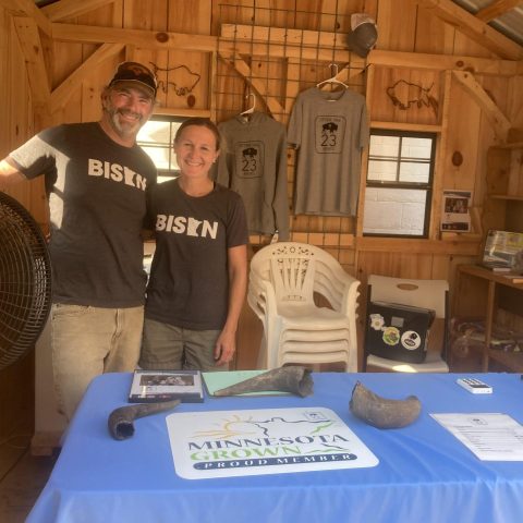 Bison farmers displaying bison horns and MN bison shirts.