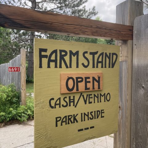 Picture of a yellow sign that says "Farmstand Open Cash/Venmo Park Inside"