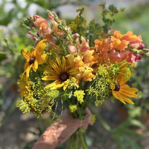 Bouquet of yellow and orange summer flowers and greenery