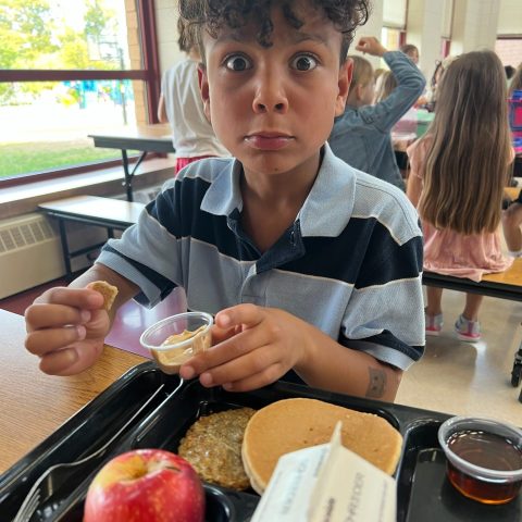 A boy at a school enjoying local foods.