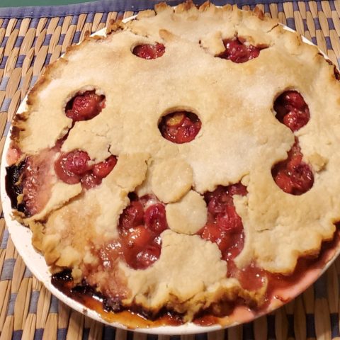 Picture of a cherry pie with top holes in the crust.