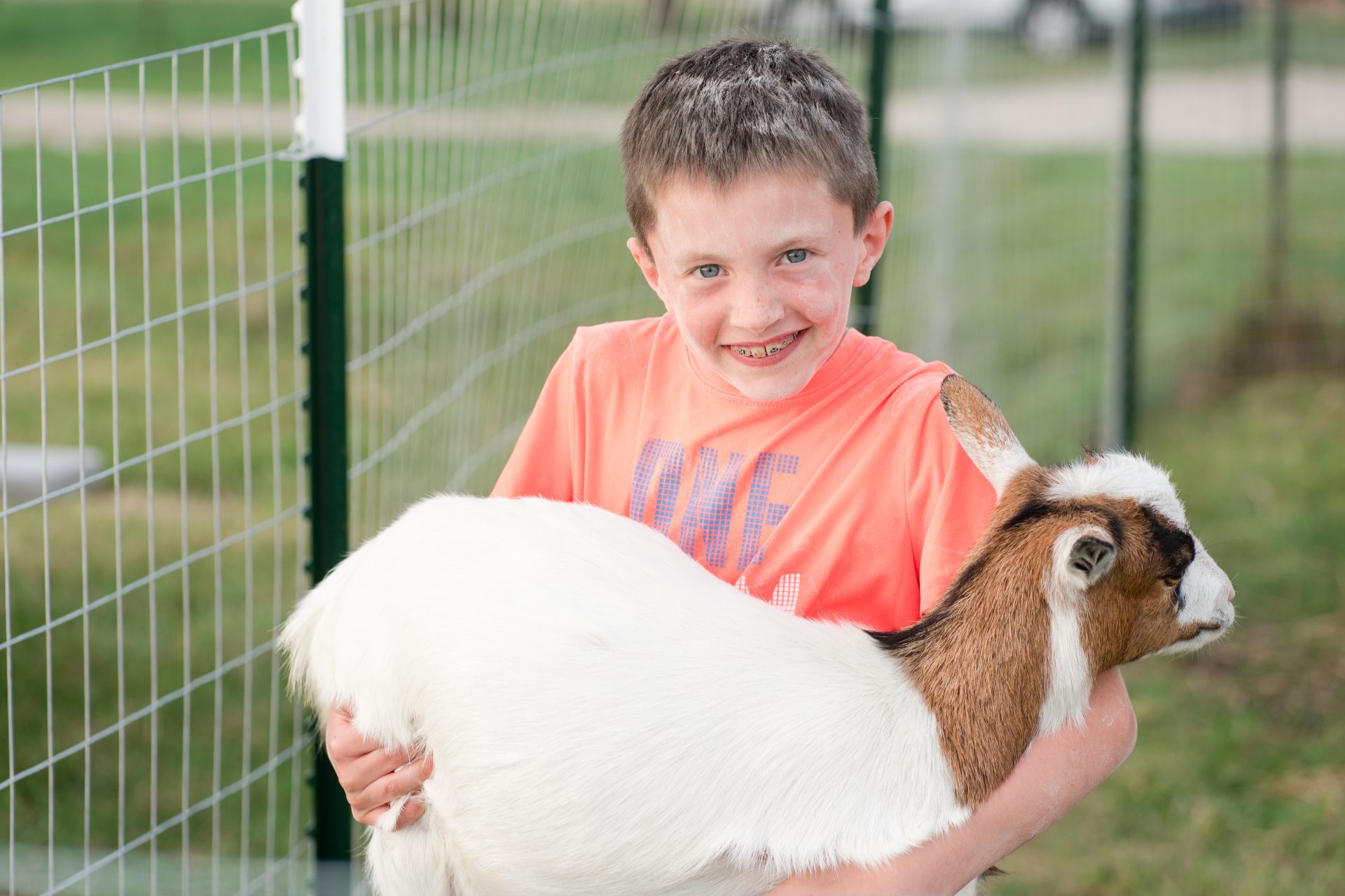 A boy holding a goat.