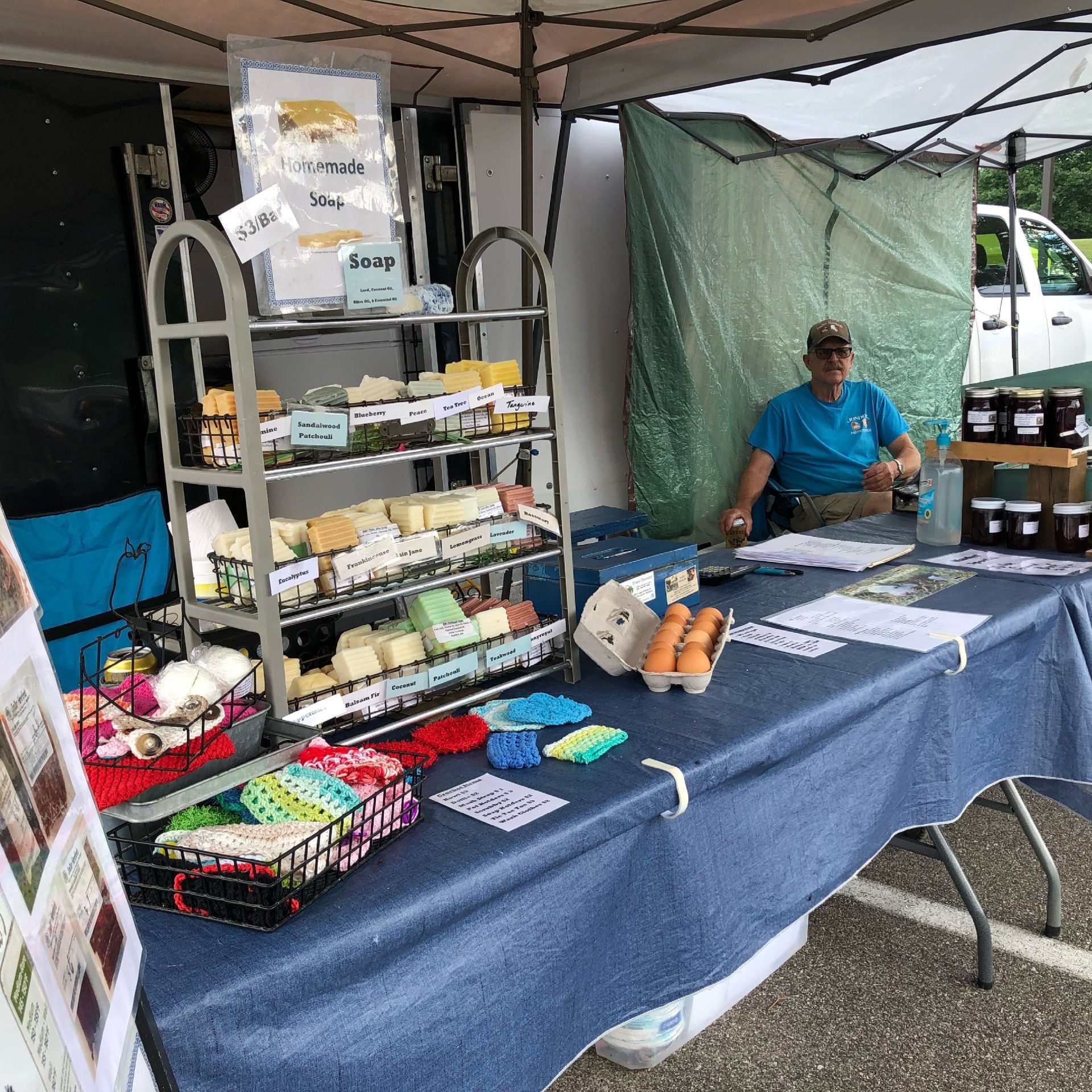 A farmers' market stand displaying soap and eggs.