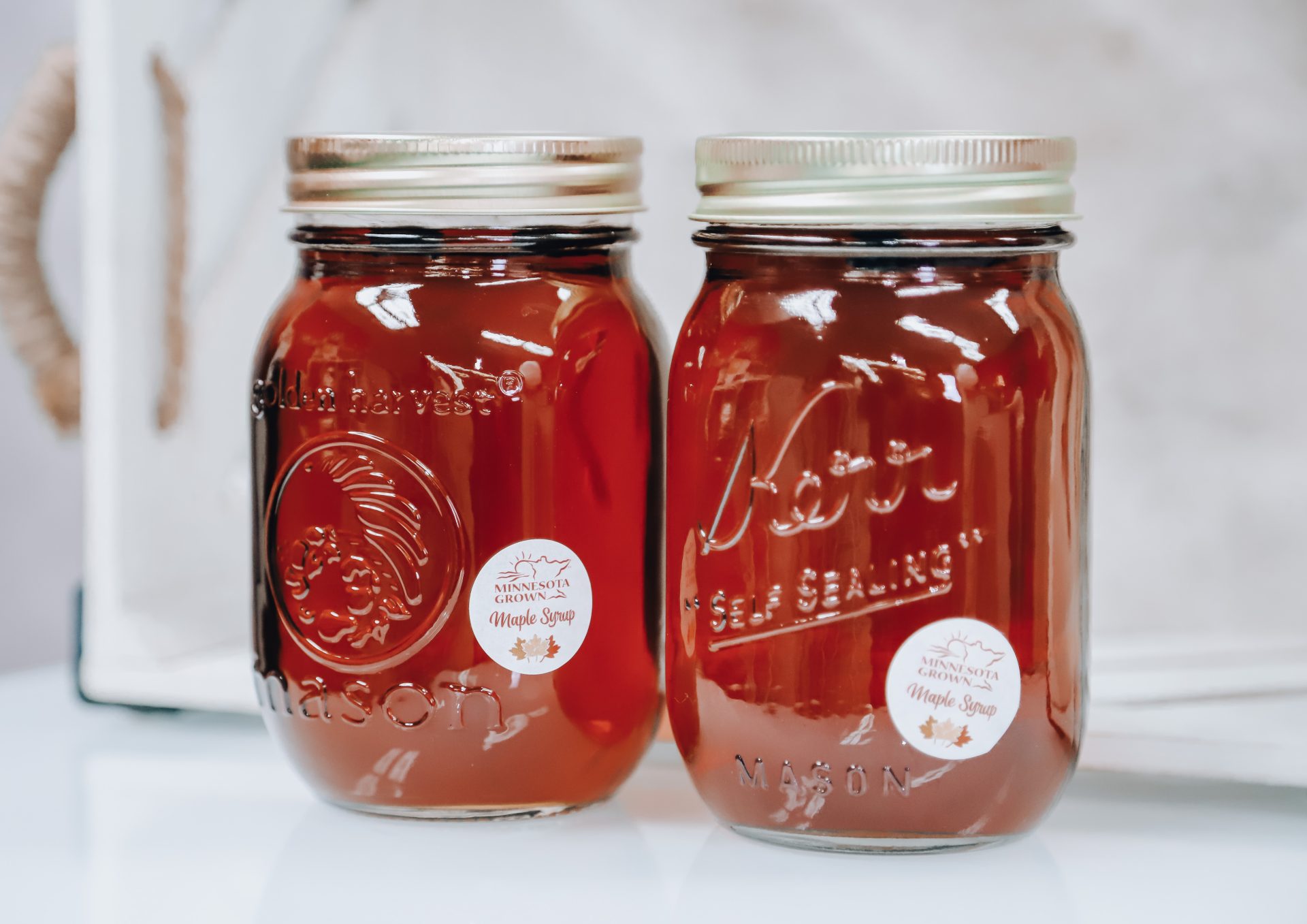 Picture of two mason jars of maple syrup against a white background with a Minnesota Grown maple syrup sticker on each.