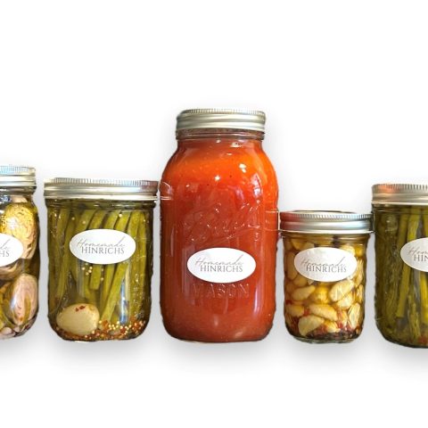 Picture of jars of pickled asparagus, garlic, salsa, and brussel sprouts against a white background.