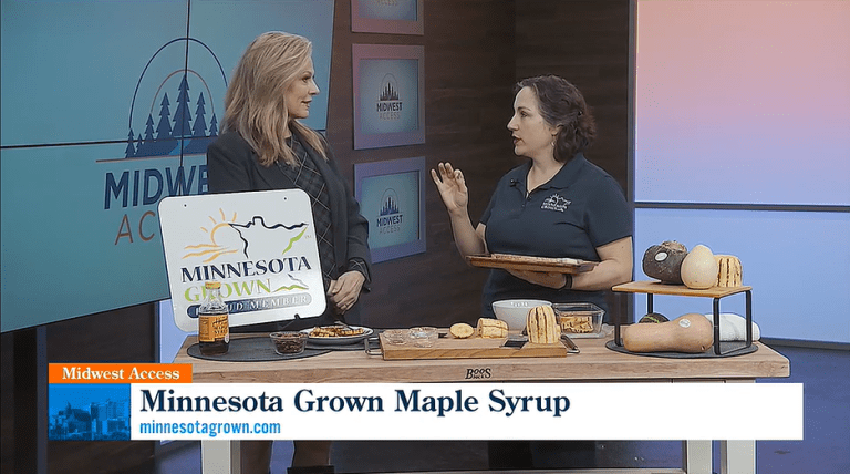 minnesota grown on midwest access two women stand behind a table full of squash and maple syrup