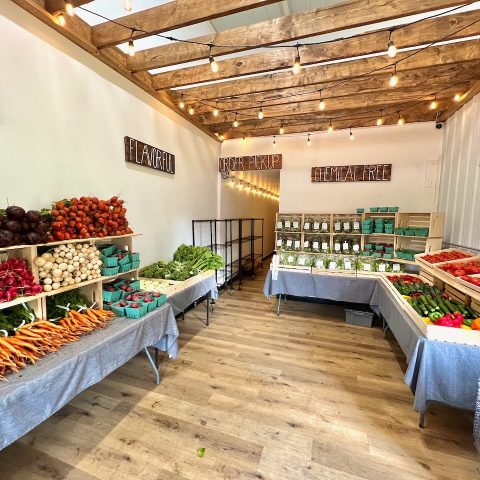 indoor farm store set up market style with fresh produce and canned goods