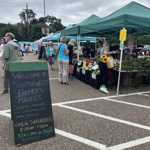 rows of market tents with customers browsing the aisles